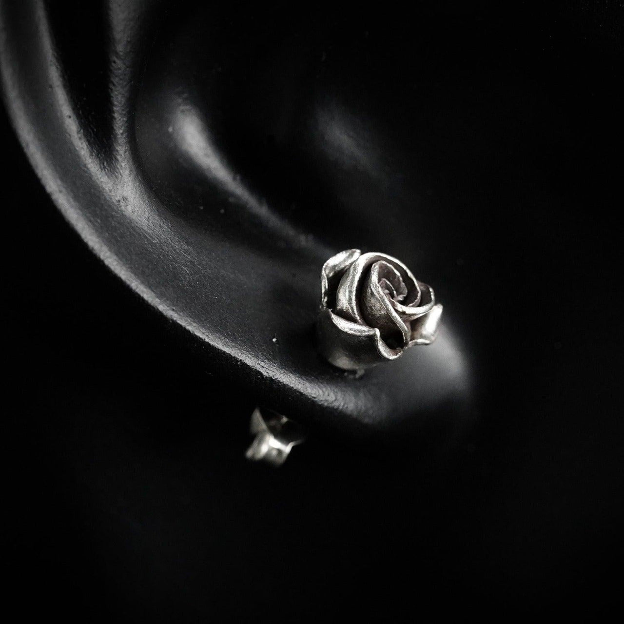 Model wearing sterling silver rose stud earrings by Black Feather Design