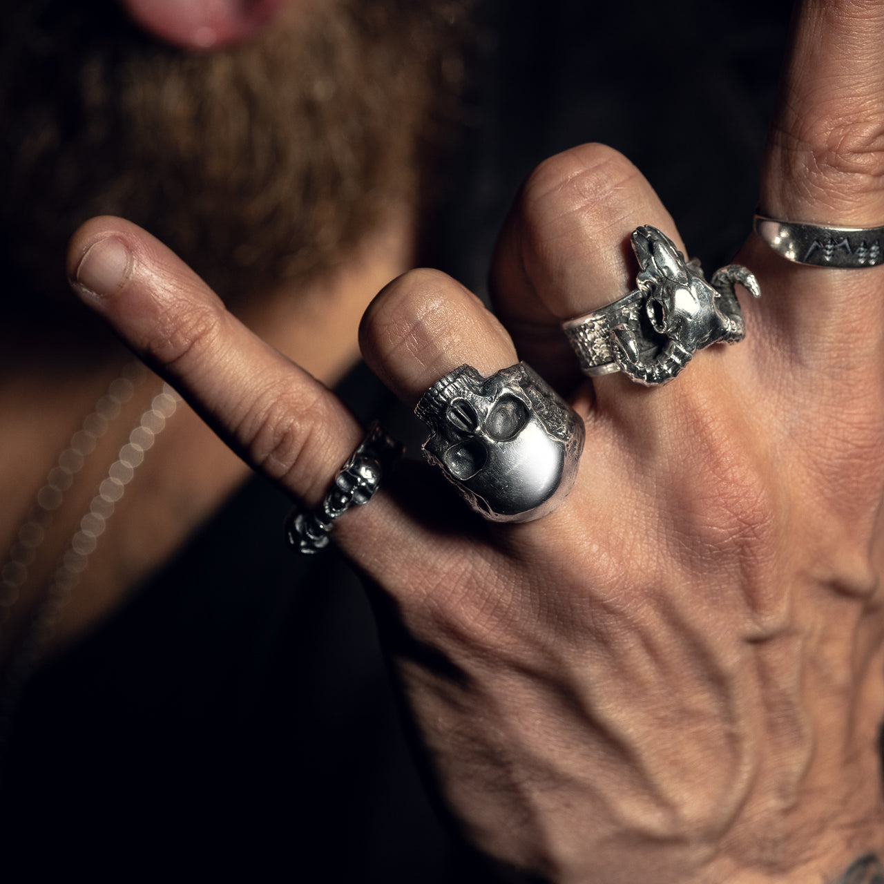 Model wearing Black Feather Design jewellery - skull rings